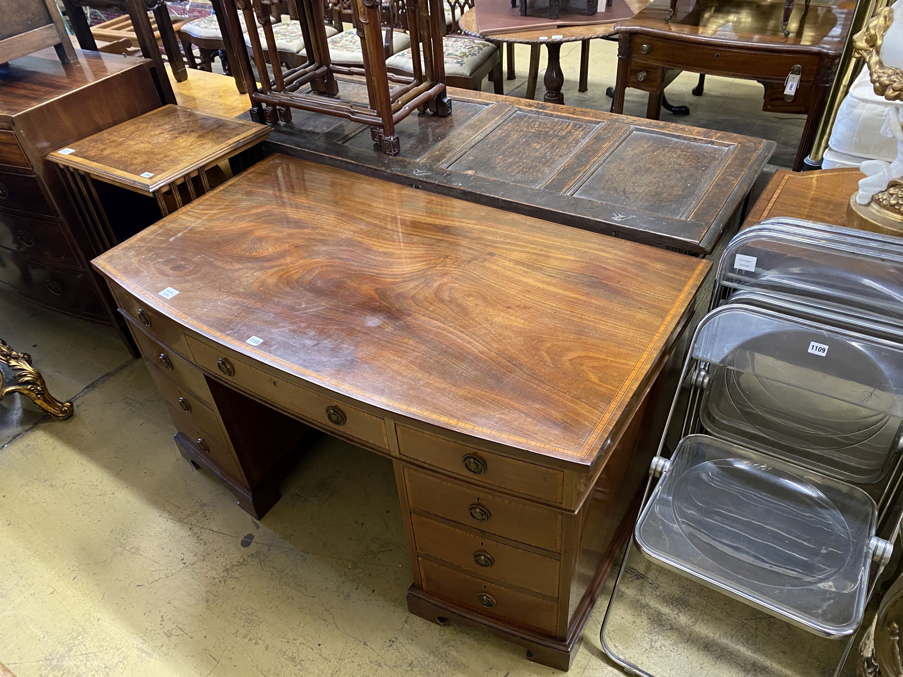 An Edwardian satinwood banded mahogany bow front kneehole pedestal desk, width 137cm, depth 76cm, height 74cm